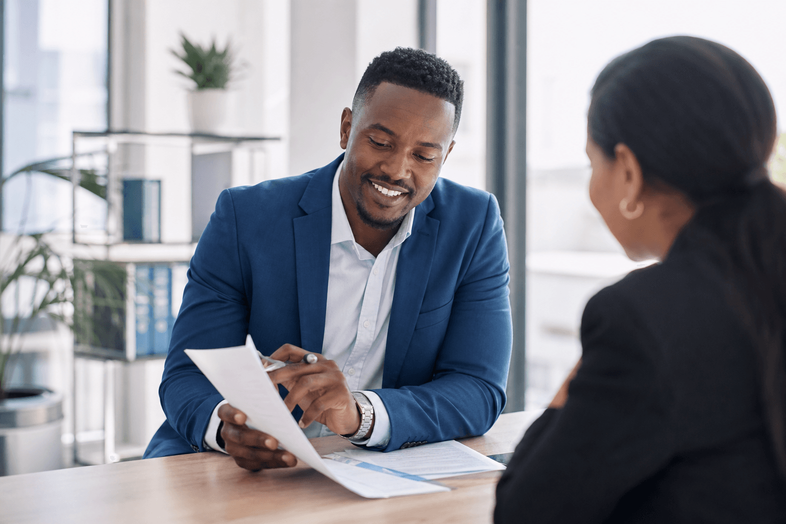 A confident professional consulting with a client in a modern office, protected by APA Professional Indemnity Insurance